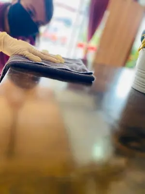 a person is wiping a rug on a table at Ct Hotel in Sitiawan