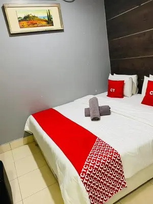 a bed with a red and white blanket on it at Ct Hotel in Sitiawan