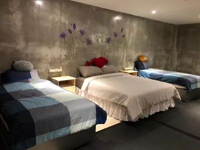 a bedroom with two beds and purple flowers on the wall at Ipoh Zing Vale - Family & Couple Suite in Ipoh