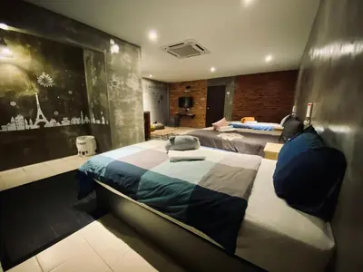 a large bedroom with two beds and a wall at Ipoh Zing Vale - Family & Couple Suite in Ipoh