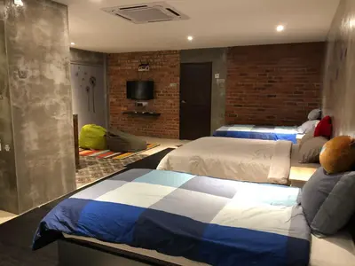 a hotel room with two beds and a tv at Ipoh Zing Vale - Family & Couple Suite in Ipoh