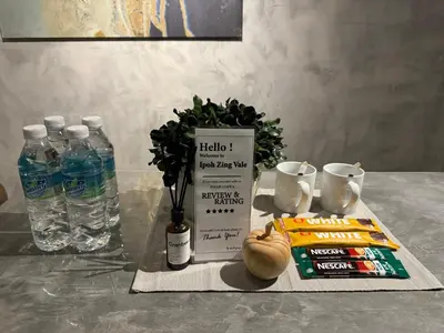 a table with a bottle of water and a book at Ipoh Zing Vale - Family & Couple Suite in Ipoh