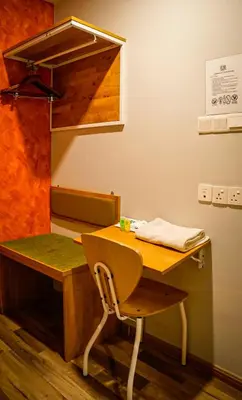 a wooden desk with a chair next to a table at K GARDEN HOTEL (IPOH) SDN BHD in Ipoh