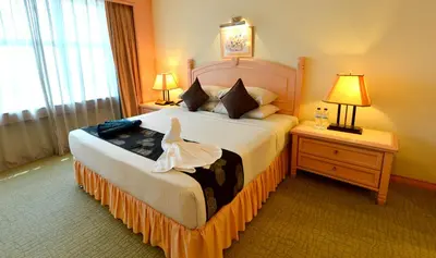 a hotel room with a bed with a dress on it at Emerald Puteri Hotel in Sungai Petani