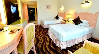 a hotel room with two beds and a desk at Emerald Puteri Hotel in Sungai Petani
