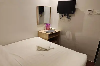 a small room with a bed and a mirror at Hotel 18 Ipoh Aeon Mall in Ipoh