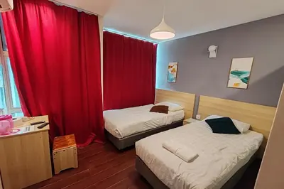 a hotel room with two beds and a red curtain at Hotel 18 Ipoh Aeon Mall in Ipoh