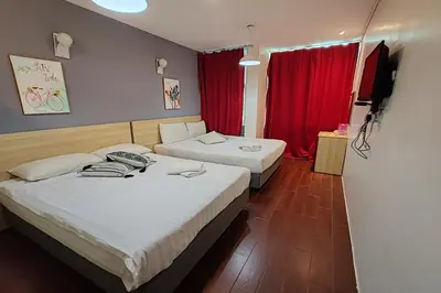 two beds in a hotel room with red curtains at Hotel 18 Ipoh Aeon Mall in Ipoh