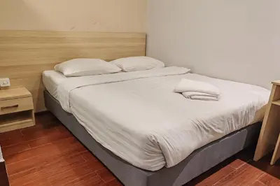 a large bed with white sheets and pillows on it at Hotel 18 Ipoh Aeon Mall in Ipoh
