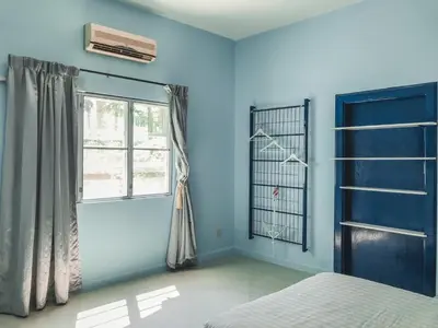 a blue room with a bed and a window at Guesthouse Dragon Place in Taiping