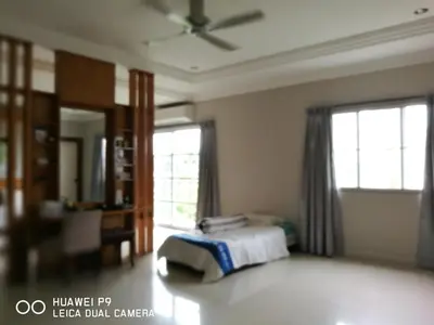 a bedroom with a bed and two windows at Guesthouse Dragon Place in Taiping