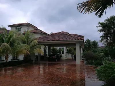a house in the rain with a driveway at Guesthouse Dragon Place in Taiping