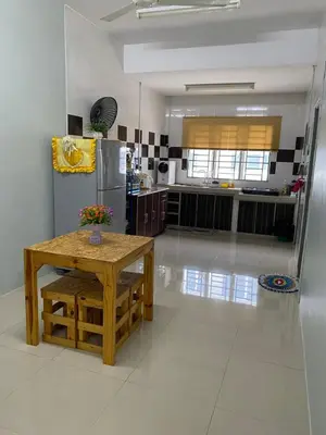 a kitchen with a table and a stainless steel refrigerator at Makmur homestay in Taiping