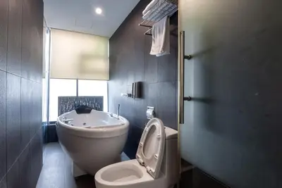 a bathroom with a toilet and a sink at Apple Hotel Times Square in George Town