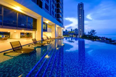 a swimming pool with chairs and a building at Tanjung Point Residences in George Town