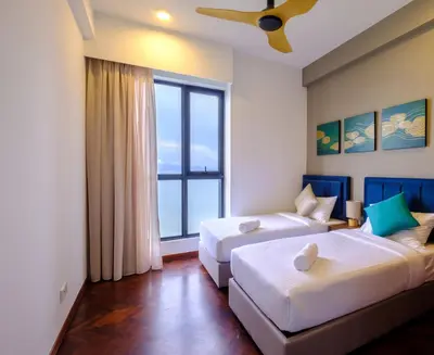 a bedroom with two beds and a large window at Tanjung Point Residences in George Town
