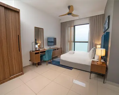 a bedroom with a bed and a desk with a computer at Tanjung Point Residences in George Town