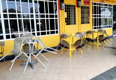 a group of chairs and tables in front of a yellow building at JV Hotel @ Simpang Ampat in Simpang Ampat