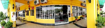 a yellow building with a bunch of windows at JV Hotel @ Simpang Ampat in Simpang Ampat