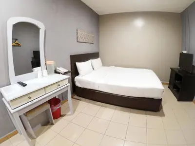 a bedroom with a bed and a sink and a mirror at JV Hotel @ Simpang Ampat in Simpang Ampat