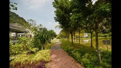 a brick path next to a river with trees at The heaven in sunway ipoh in Ipoh