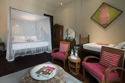 a bedroom with a bed and two chairs and a table at Noordin Mews in George Town