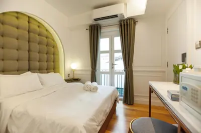 a bedroom with a large white bed with a large window at White Mansion Penang in George Town