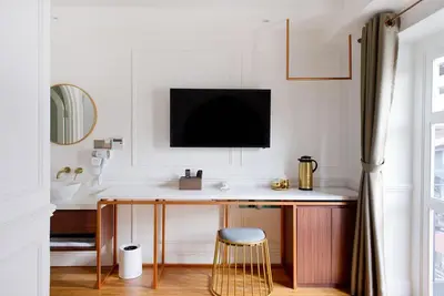 a room with a desk with a tv on the wall at White Mansion Penang in George Town