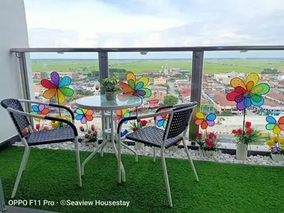 a balcony with a table and chairs and a view at WindMill SunRise PaddyView Homestay in Sekincan