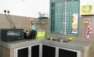 a kitchen with a sink and a microwave at Qstay Sitiawan Townhouse (Minnie Dreams) - \u7c73\u59ae\u68a6 in Sitiawan