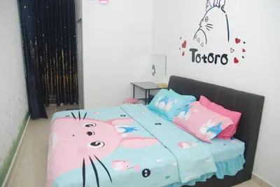 a bedroom with a bed with a hello kitty blanket at Qstay Sitiawan Townhouse (Totoro Dreams) - \u68a6\u89c1\u9f99\u732b in Sitiawan