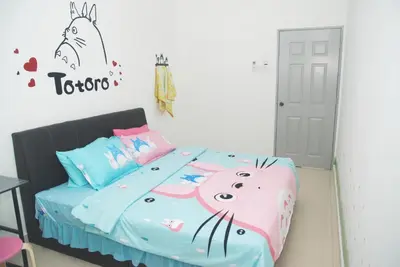 a bedroom with a bed with a hello kitty comforter at Qstay Sitiawan Townhouse (Totoro Dreams) - \u68a6\u89c1\u9f99\u732b in Sitiawan