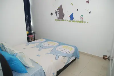 a bedroom with a bed with two pillows on it at Qstay Sitiawan Townhouse (Totoro Dreams) - \u68a6\u89c1\u9f99\u732b in Sitiawan