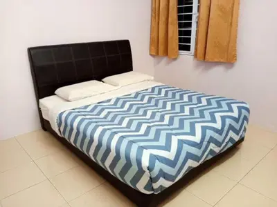 a bed with a blue and white comforter in a room at Mag Homestay at Crown Imperial Court, Brinchang in Cameron Highlands