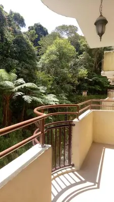 a balcony with a railing with trees in the background at Mag Homestay at Crown Imperial Court, Brinchang in Cameron Highlands