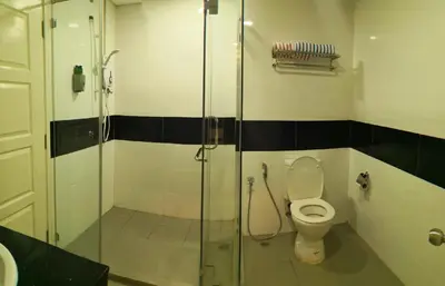 a bathroom with a toilet and a glass shower at Mansion One by Sky Hive in George Town