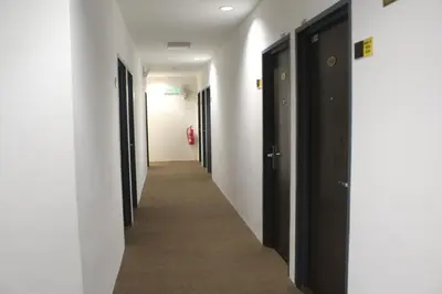 a hallway with black and white doors and a carpeted hallway at Grand Inn Hotel - Macalister Road in George Town