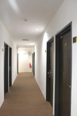 a corridor of a hallway with black doors at Grand Inn Hotel - Macalister Road in George Town