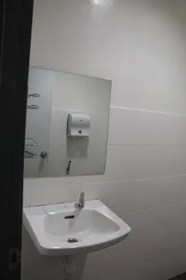 a bathroom with a white sink and a mirror at Grand Inn Hotel - Macalister Road in George Town