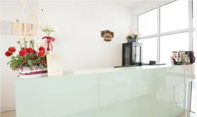 a white counter with flowers on top of it at Grand Inn Hotel - Macalister Road in George Town