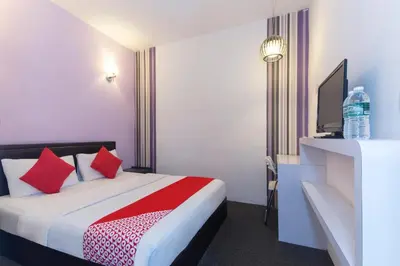 a hotel room with a bed with red pillows at Hotel O Marvelton Hotel in Butterworth