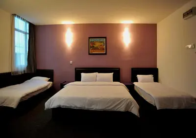 a hotel room with two beds with white sheets at Hotel O Marvelton Hotel in Butterworth