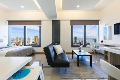 a bedroom with a bed and a couch and a table at Tropicana 218 Macalister in George Town