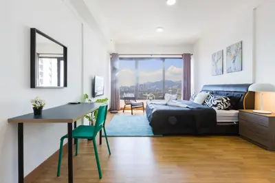 a living room with a bed and a table and a desk at Tropicana 218 Macalister in George Town