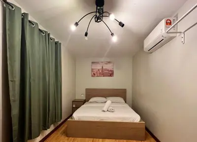 a bedroom with a bed and a green curtain at Petak Padin Cottage by The Pool, Kepala Batas Penang in Kepala Batas