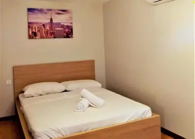 a bed in a bedroom with a picture on the wall at Petak Padin Cottage by The Pool, Kepala Batas Penang in Kepala Batas