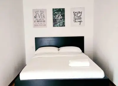 a bed in a room with two posters on the wall at Petak Padin Cottage by The Pool, Kepala Batas Penang in Kepala Batas