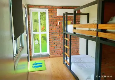 a room with a bunk bed and a brick wall at Petak Padin Cottage by The Pool, Kepala Batas Penang in Kepala Batas