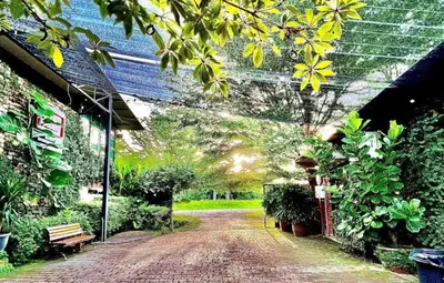 a brick walk way with plants and a bench at Petak Padin Cottage by The Pool, Kepala Batas Penang in Kepala Batas
