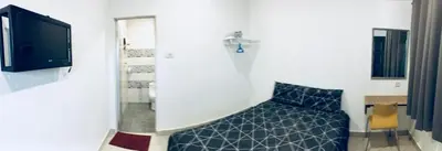 a bedroom with a blue bed and a tv at LunaStay (Shared Common Area) in Lunas